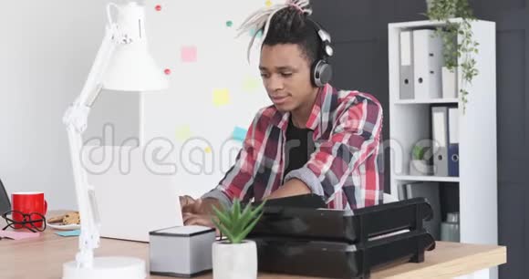 商人一边欣赏音乐一边贴着笔记本电脑的黏贴纸条视频的预览图