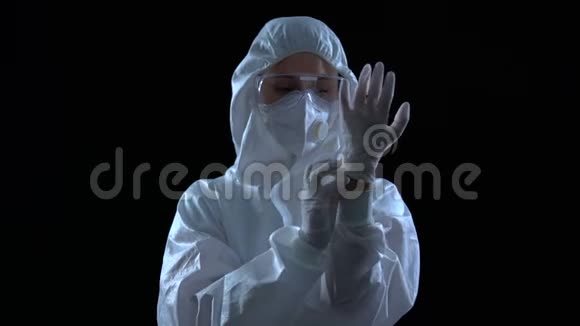穿防护服的人在黑暗背景下戴橡胶手套毒素视频的预览图