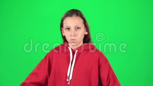小女人生气不满意地站在她的臀部绿色背景慢动作视频的预览图