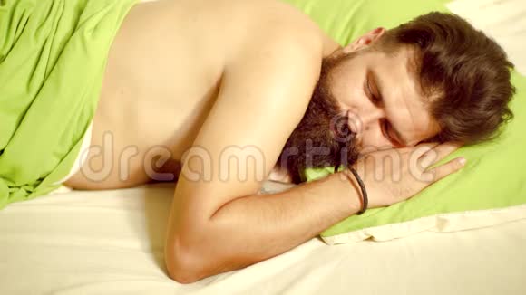 帅哥睡觉抱着柔软的绿色枕头的照片帅哥睡在卧室里躺在床上青年视频的预览图