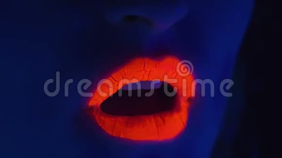 在紫外线下涂有红色嘴唇的年轻女子视频的预览图