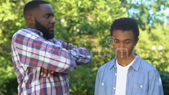 严格的黑人父亲看着有罪的十几岁的儿子教养方式家庭视频的预览图