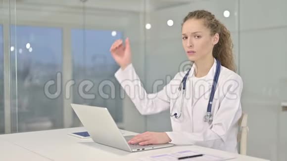 雄心勃勃的年轻女医生在办公室做大拇指视频的预览图