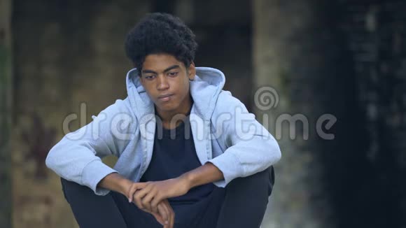 可悲的美国黑人少年独自一人坐在街头思考问题视频的预览图