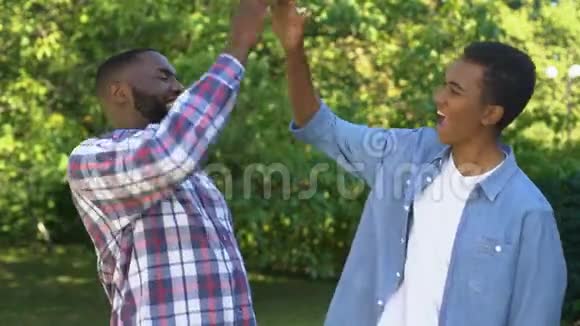 快乐的黑人男子给高五快乐的兄弟享受在一起的时光视频的预览图