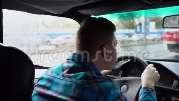 一个年轻人在开车雨天从后座上看到一个男人视频的预览图
