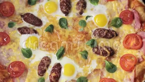带有奶酪番茄香肠和鸡蛋的特写披萨围绕着自己从顶部可以看到视频的预览图