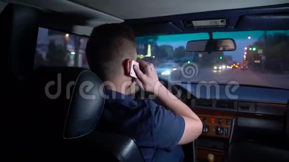 一个年轻人开车打电话从后座上看到一个男人视频的预览图