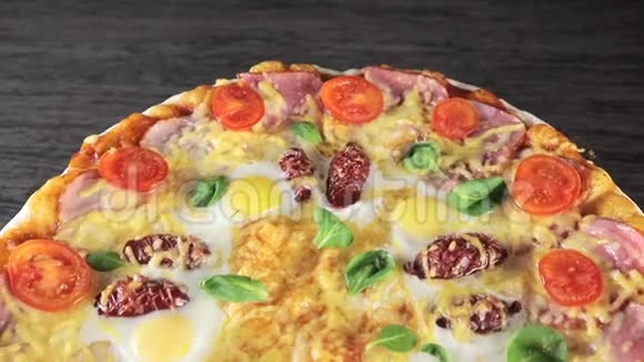 带有奶酪番茄香肠和鸡蛋的特写披萨围绕着自己从顶部可以看到视频的预览图