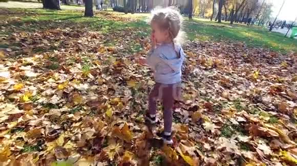 小女孩在秋天的公园里跑开大笑视频的预览图