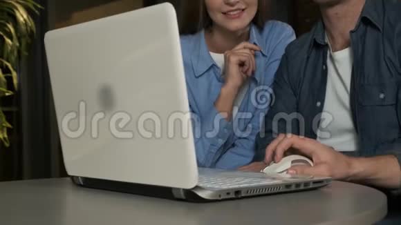 在办公室开会的时候年轻人用手指指着笔记本电脑年轻家庭上网购物视频的预览图