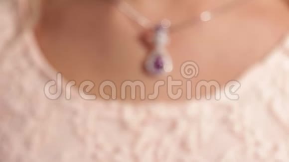 珠宝一个银色的吊坠在漂亮女孩的脖子上一颗洋红钻石景深较浅视频的预览图