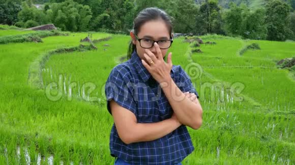 农夫亚洲女人站着跨过一只的手臂骄傲地站在稻田里视频的预览图