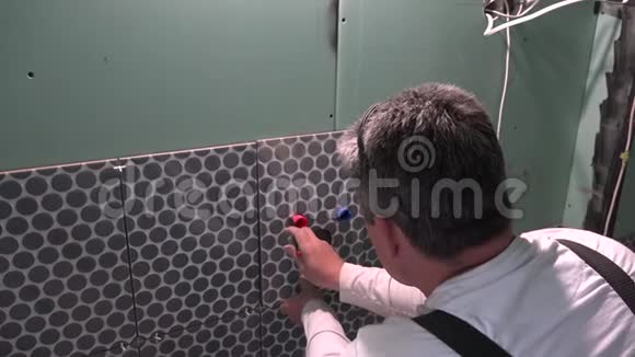 专业的杂工工人在瓷砖上做记号扩大孔视频的预览图