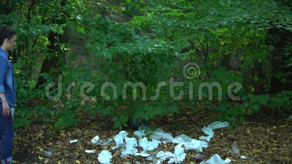 担心女性持有拯救星球标志行走森林填埋塑料垃圾视频的预览图