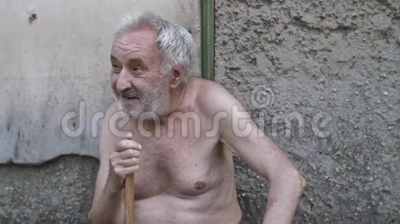 一个拿着拐杖的老人坐在街上视频的预览图