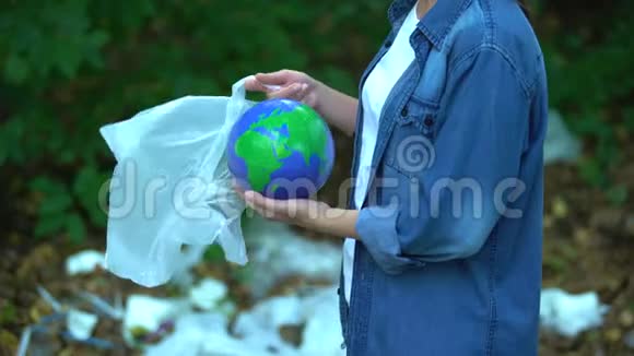 女性把行星放进塑料袋扔进垃圾填埋场污染地球视频的预览图