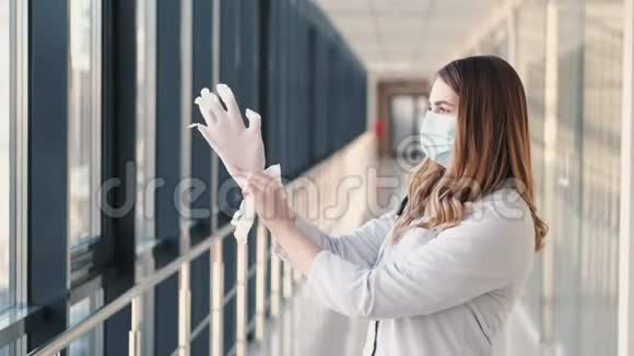 一名戴口罩的护士正在放置一次性橡胶白手套视频的预览图