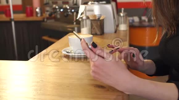 一个女孩的手在咖啡店里用平板电脑特写慢动作视频的预览图