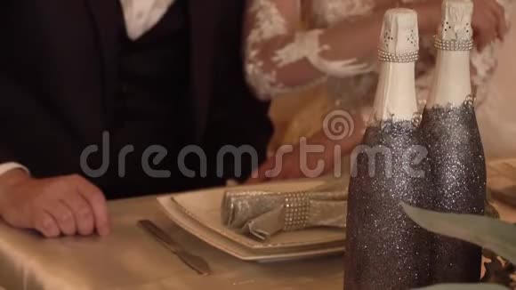 新郎新娘正拿着香槟酒杯坐在婚礼桌旁视频的预览图