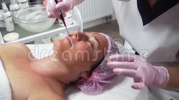 美容师在成年女性脸上敷上治疗面膜视频的预览图