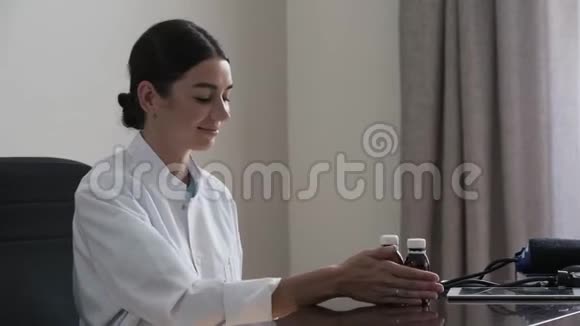 一位专业的年轻女医生提供蔬菜坐在办公室看相机的肖像健康视频的预览图