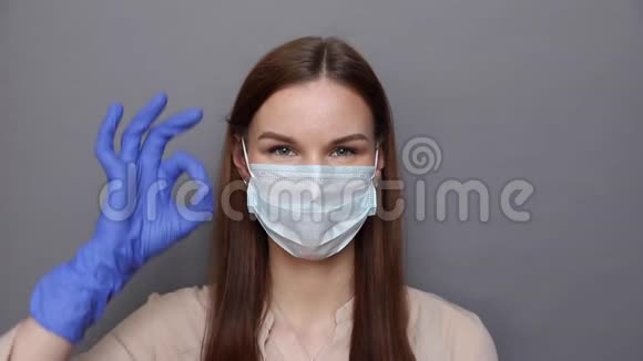 戴着防护面罩和手套的女人用滑稽的方式表现出良好的标志视频的预览图