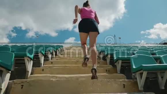 一个年轻女孩在体育场楼上奔跑的背影视频的预览图