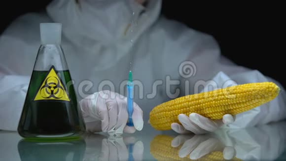 生物学家拿着注射器和玉米桌上放着有生物危害的液体的烧瓶视频的预览图
