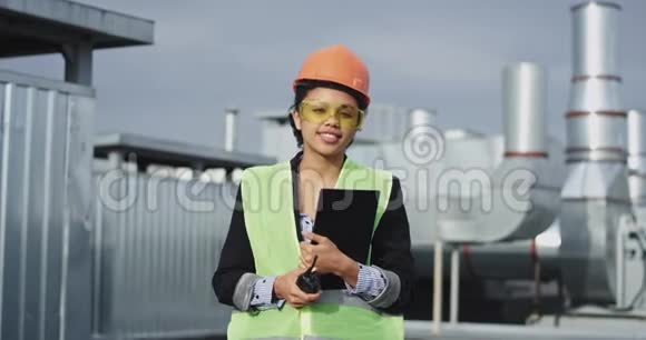 在建筑工地屋顶上戴着头盔的非洲魅力女工程师的镜头前视频的预览图