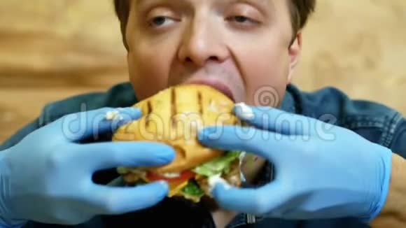 有趣的饿汉在快餐店吃汉堡小伙子非常高兴喜欢吃视频的预览图