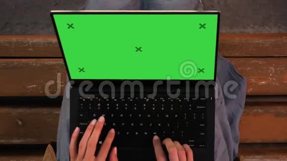 坐在长凳上的女人在笔记本电脑上打字视频的预览图