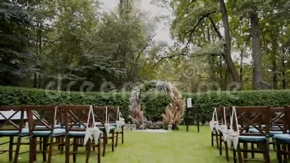 婚礼拱门和椅子装饰着森林里的天然花朵视频的预览图