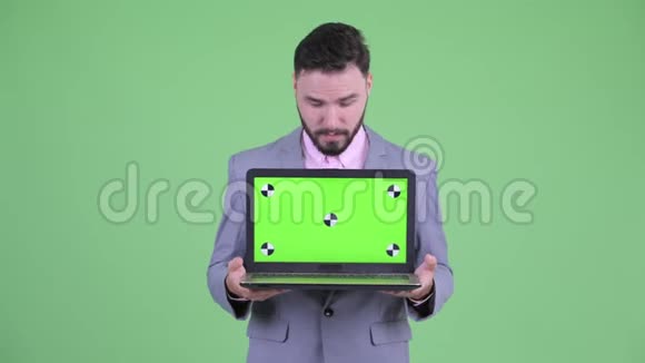 穿着小胡子的商人展示笔记本电脑视频的预览图