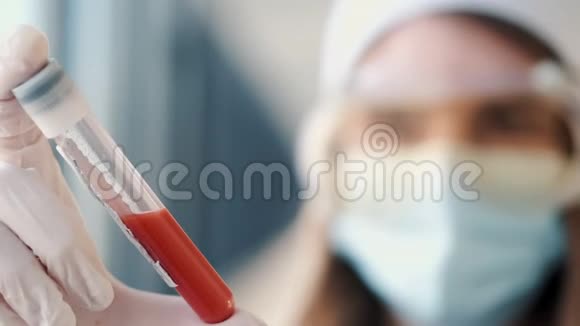 戴着医用帽子和口罩的女医生正拿着一瓶血视频的预览图