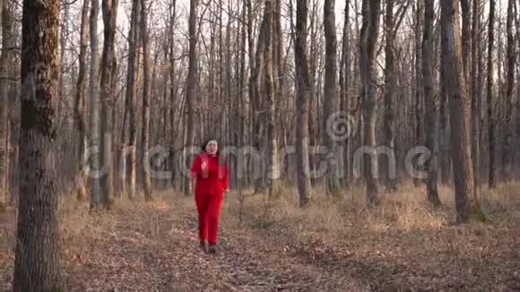 绿油油的胖姑娘穿着红色的衣服穿过秋天的森林停下来放松视频的预览图