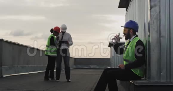 男工程师留着胡子在施工现场安全设备从塑料瓶里喝水笑着可爱到视频的预览图