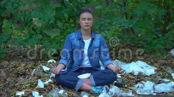 冥想女人戴上防护面具坐在公园垃圾填埋场空气污染视频的预览图