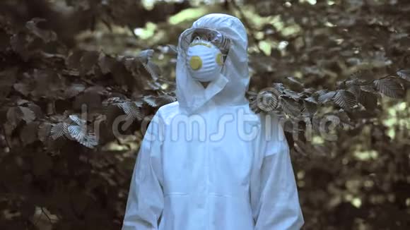 穿着防护制服的女人站在被污染的森林前塑料填埋场视频的预览图