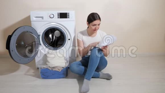 家庭主妇学习地板上新洗衣机的设置视频的预览图