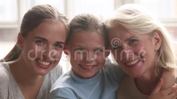 三代女性拥抱室内欢笑的特写镜头视频的预览图