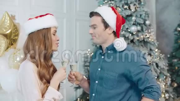 可爱的男人和女人一起在圣诞老人的帽子上许愿视频的预览图