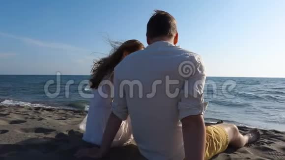两个人坐在沙滩上互相交谈视频的预览图
