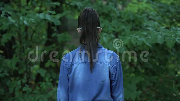 戴防护面具的女性看着摄像机站在森林里视频的预览图