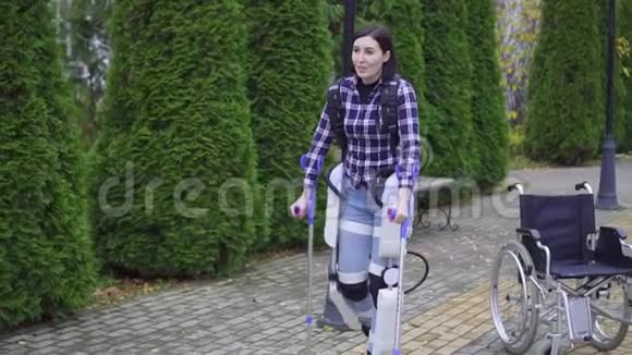 年轻残疾妇女使用外骨骼在公园散步视频的预览图