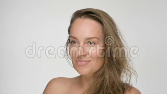 年轻女性的特写美女肖像皮肤光滑健康她在白色背景上解开头发微笑视频的预览图