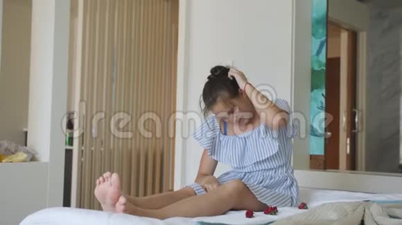 一个十几岁的女孩漫无目的地坐在旅馆的床上视频的预览图
