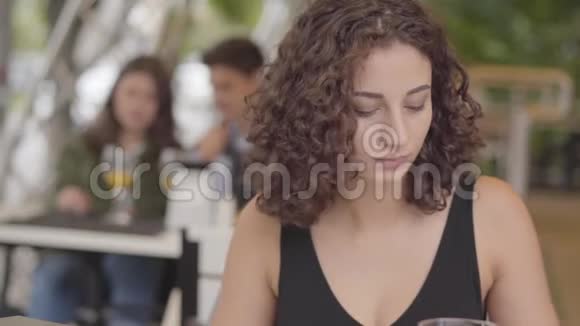 可爱的年轻卷曲的女人在街头咖啡馆吃美味的肉菜和土豆在户外享受甜点放松的女孩视频的预览图