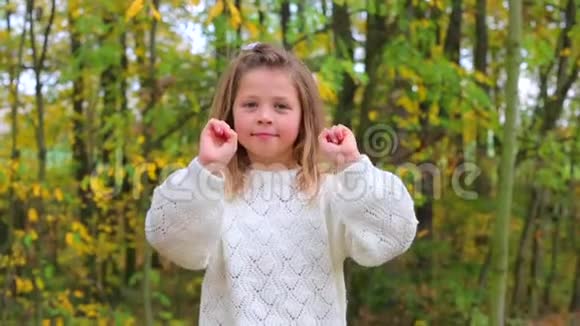 一个穿着白色衣服的女孩在秋天的森林里摆姿势视频的预览图