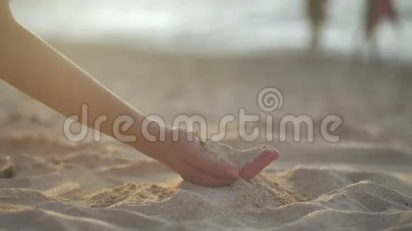 女人手里拿着沙子在海滩上4k视频的预览图